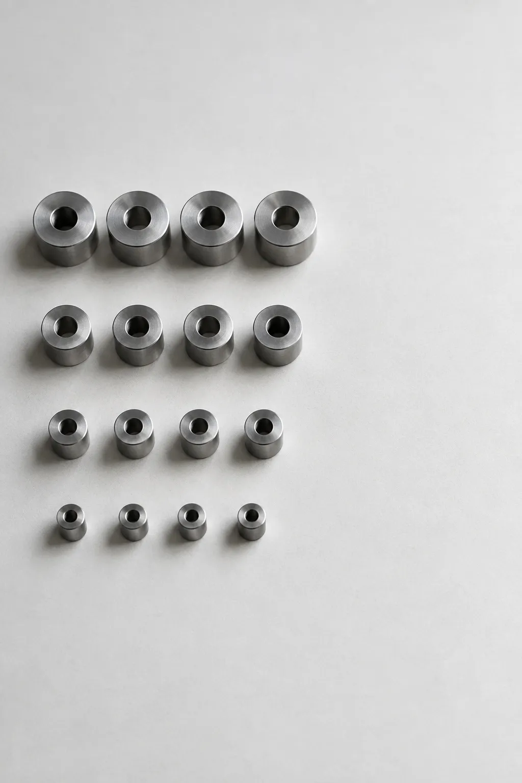 Small metal parts sorted into neat rows on a white surface